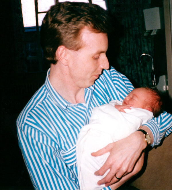 Restored image of father holding newborn baby