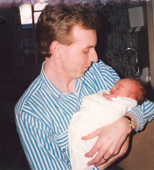 Damaged image of father holding newborn baby